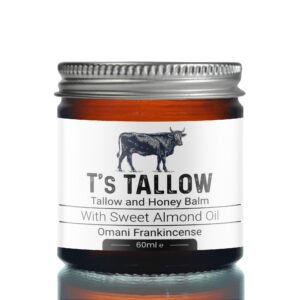 Close-up of a bottle cap and label featuring a cow illustration and the words 'It's Tallow' and 'Talllow and Honey Balm' with almond oil.